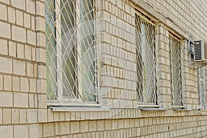 Three old white windows behind an iron grate