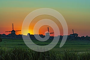 Three old windmills from the year 1672 in Stompwijk Molendriegang Stompwijk, the Netherlands during a beautiful sunset