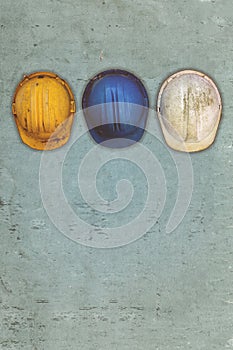 Three old and worn construction helmets