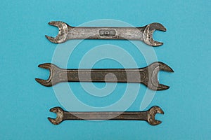Three old wrenches on a blue background