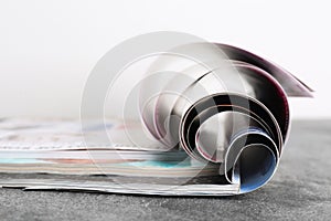 Three open magazines on grey stone table