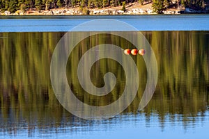 Three orange buoys float in Lake Britton at Burney Falls Memoria