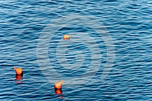 Three Orange Mooring Buoys on the Sea