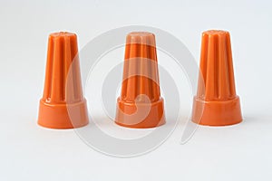 Three Orange Plastic Electrical Caps