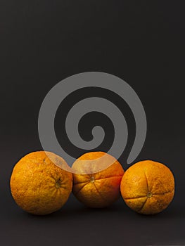 Three oranges on a black background