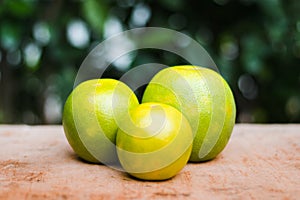 Three oranges of different sizes on a wooden table