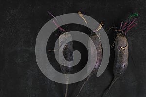 Three organic beets on a dark background. Organic eco food. Healthy diet. Freshly picked vegetables.