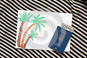 three painted with paint palm trees on white paper, painted with paints palm tree, and next to it lie a passport and
