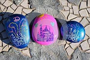 Three painted rocks resembling the castle at Disneyland