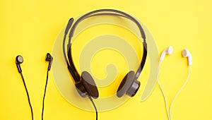 Three pairs of headphones on a yellow background. Clubhouse social media concept.
