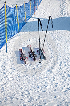 Three pairs of skis and two poles in the snow