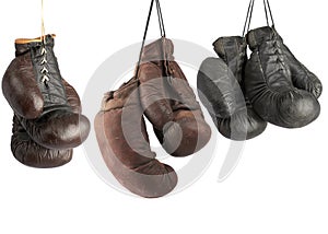 three pairs of very old vintage leather boxing gloves hanging on laces