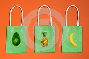 Three paper bags with fruits, banana, pineapple and avocado icons. Food delivery from a store, cafe or restaurant