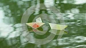 Three paper boats adrift in the river