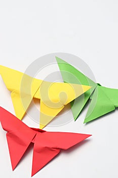 Three paper butterflies in red, green and yellow.