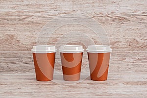 Three paper disposable cups with lids for coffee or tea