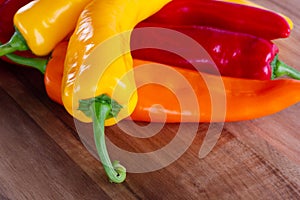 Three paprikas on wooden board