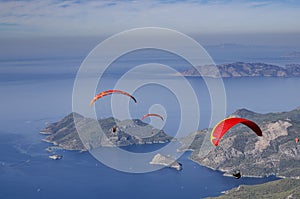 Three paragliders fly over the coastline from the top of Babadag,