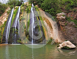 Three parallel streams fall in oval pool