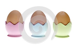 Three Pastel Egg Cups with Brown Eggs