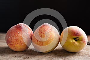 Three peaches fruit on wooden