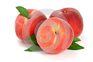 Three peaches with green leaf isolated on white background