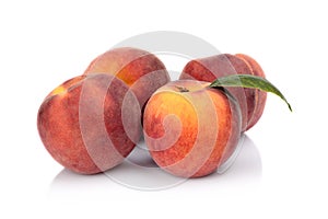 Three peaches with leaf isolated on white