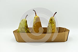 Three pears in a cardboard box isolated on white background