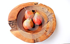 Three pears in a teak wood bowl on a white background.Natural food. Fruit for juices and jellies.Fruits concept.