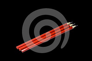 Three pencils in isolate on a black background, red color of simple graphite pencils