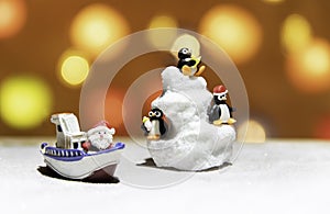 Three Penguins on ice mountain with Santa on boat