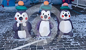 Three penguins in a marine uniform on the New Year holiday. Decorative statues