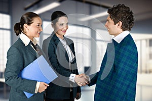 Three people in business attire shake hands
