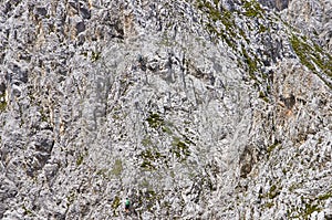 Three people climbing on a limestone wall with wide valley on the background. Mountain background.