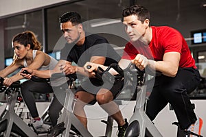 Three people doing cardio on a bicycle
