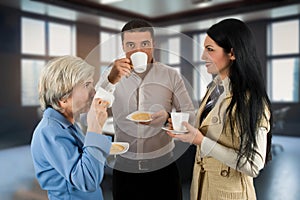 Three people dressed casually in the conference room drinking coffee