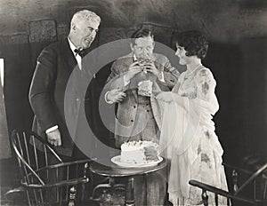 Three people enjoying a slice of cake