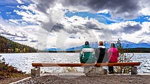 Three people enjoying the view of Pyramid Lake in Jasper National Park