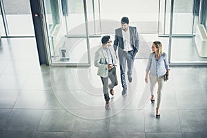 Three people entering the business building. photo