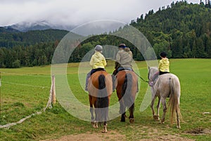 three people on horses in country