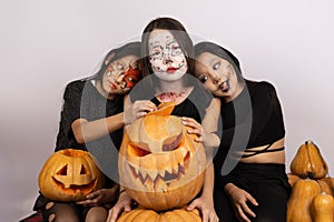The three people are posing with painted faces for a Halloween-themed photo