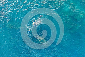 Three people snorkling in the ocean in Amed, Bali, Indonesia