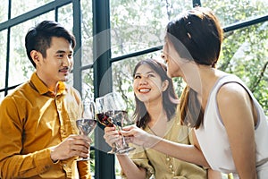 Three people toasting red wine at restaurant