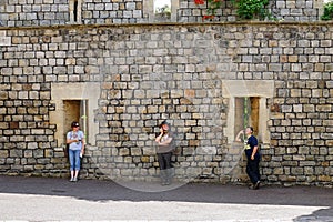 Three people using electronic devices in perfect symmetry.