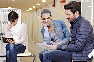 three people in waiting area for medical appointment
