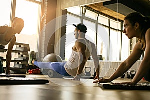 Three people workout in healthy club.