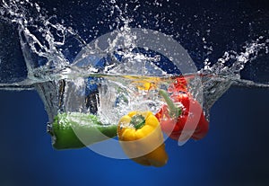 Three peppers falling into water