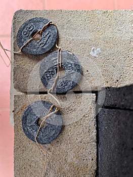 Three perforated coins were placed on the wall