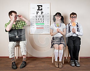 Three person wearing spectacles in an office at the doctor