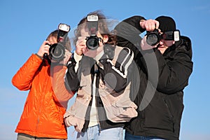 Three photographers against blue sky